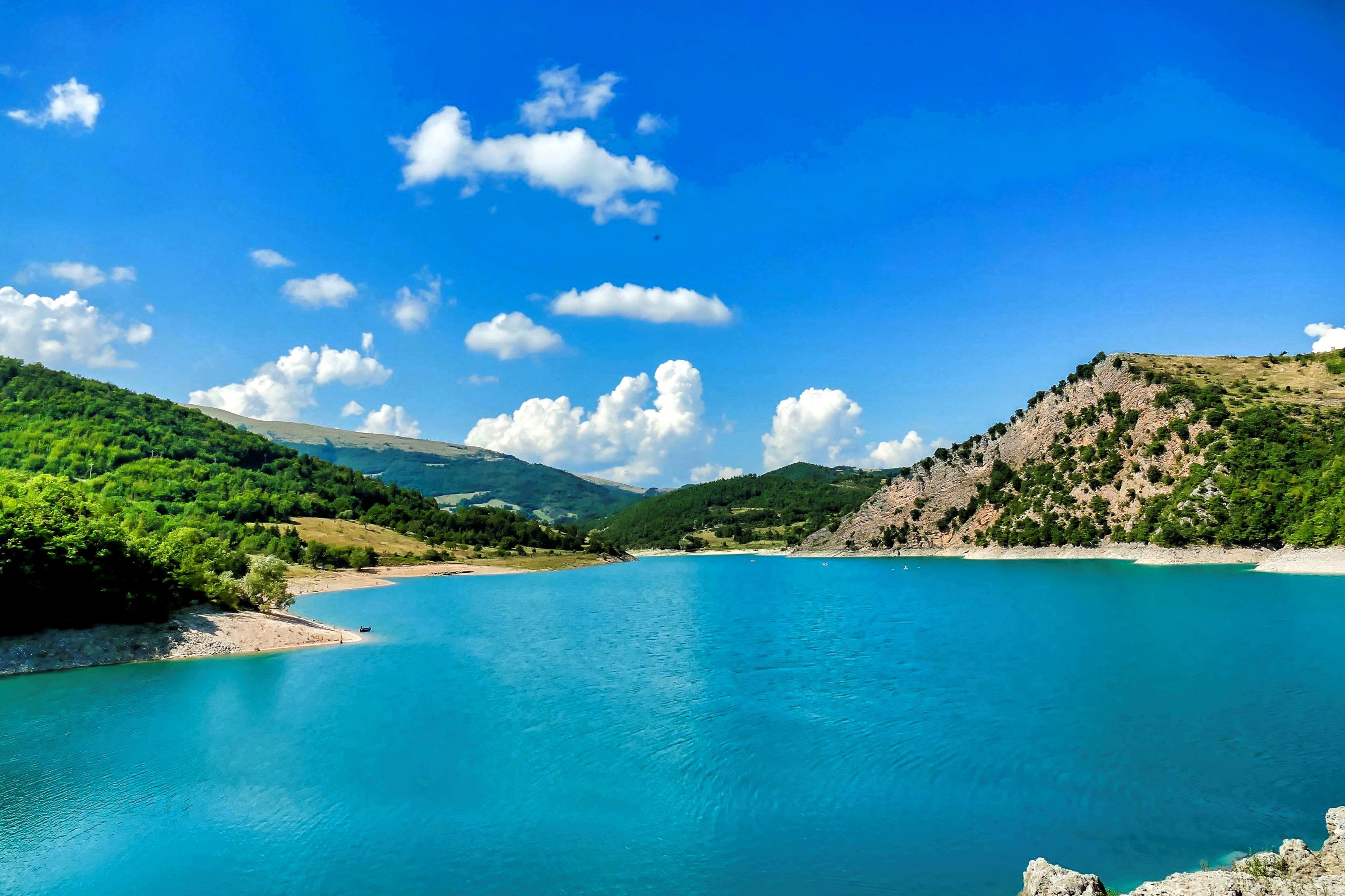 beautiful-shot-pond-surrounded-by-mountains-blue-sky-umbria-italy.jpg